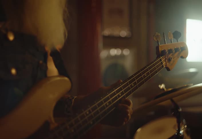 Two white bearded men one playing drums and the other playing guitar