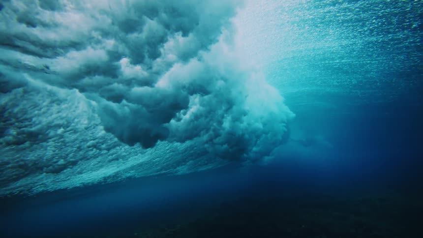 The waves move up and then crash in the blue water