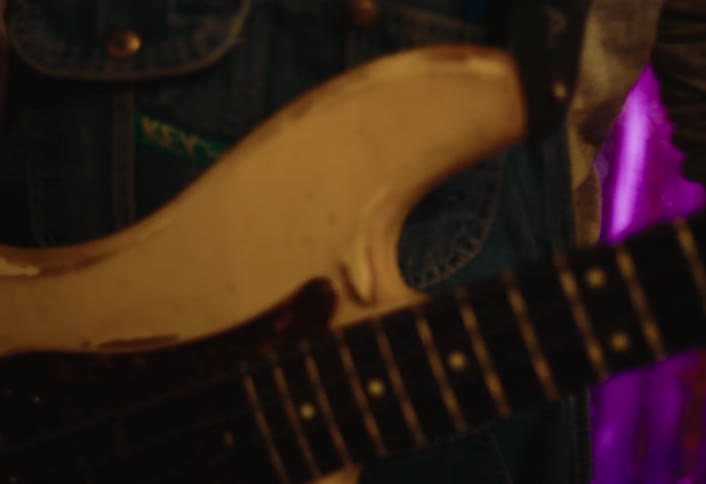 A man is strumming his guitar