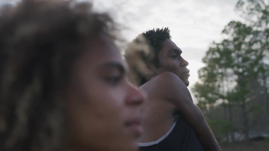 Close up of a young couple stretching near a forested rural area at morning