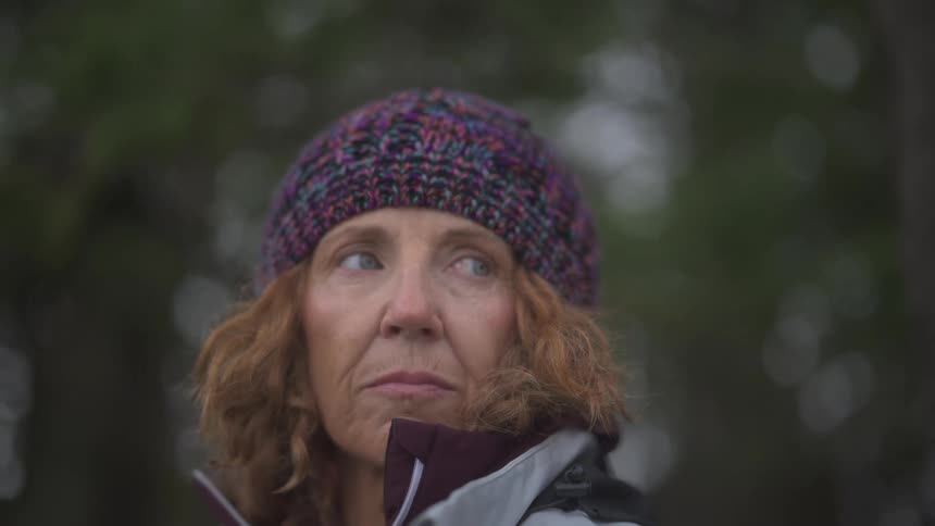 A woman turns her head outside