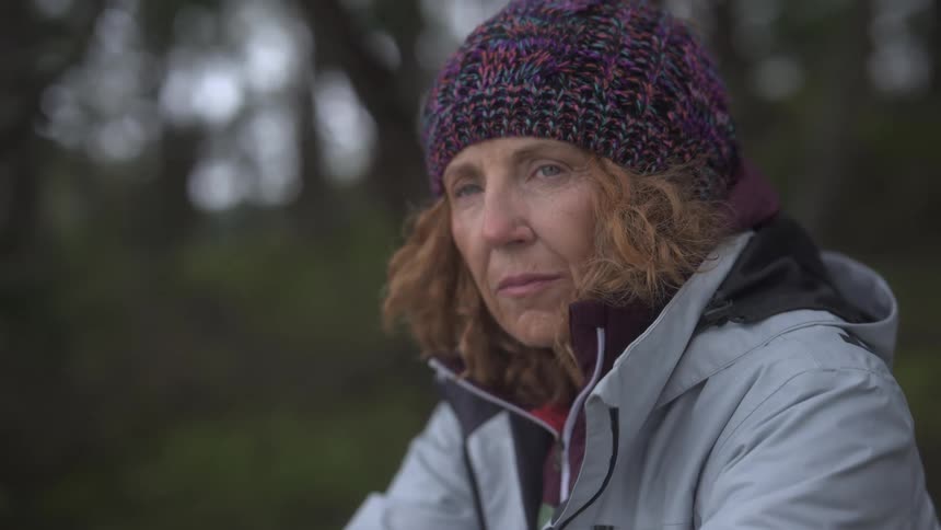 A woman is sitting in the forest