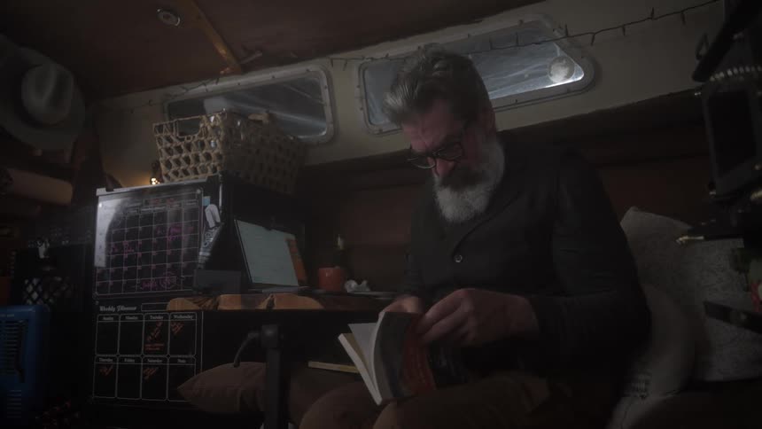 A man talks while reading a book