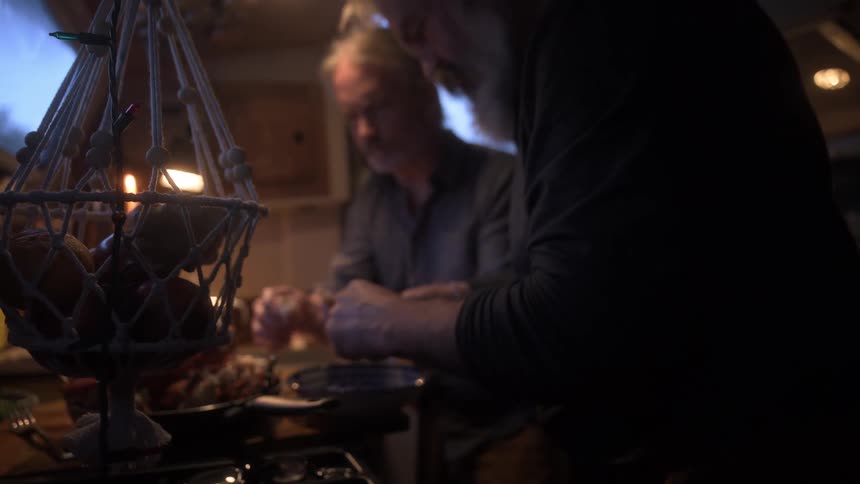 Two men cooking in a cabin