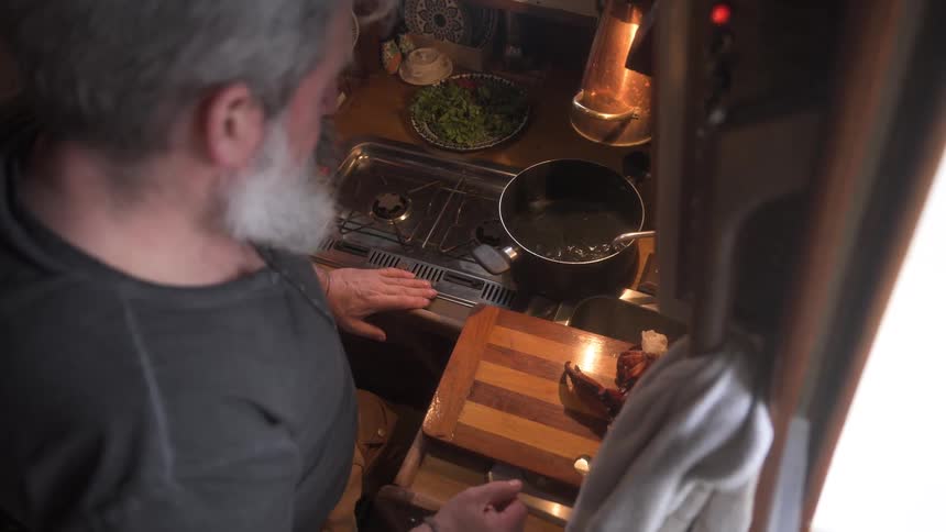 Man anxiously watching pot fill with water then sets it on the stovetop