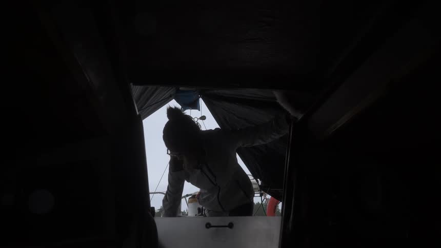 Silhouette of a person entering a cabin from a corridor