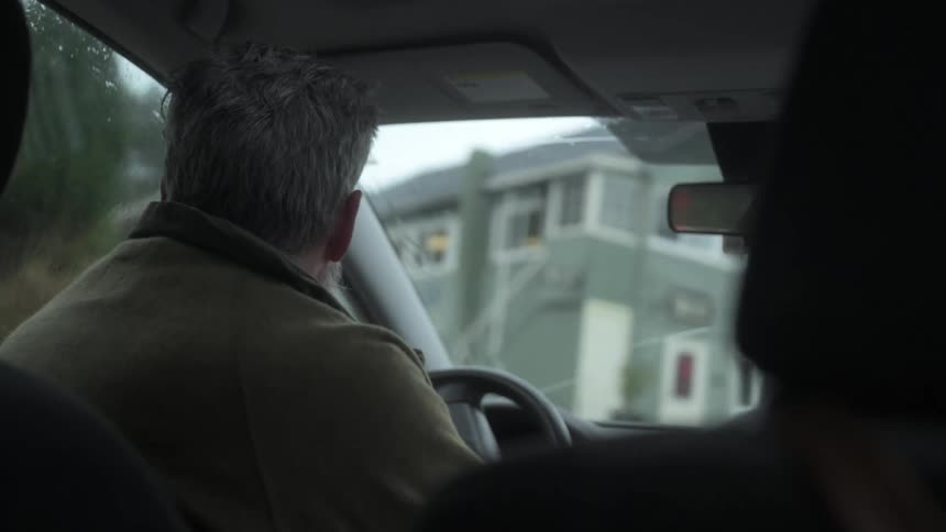 Man driving a vehicle during the day and in the rain