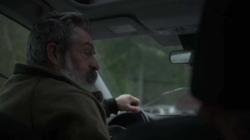 Gray bearded man driving a vehicle