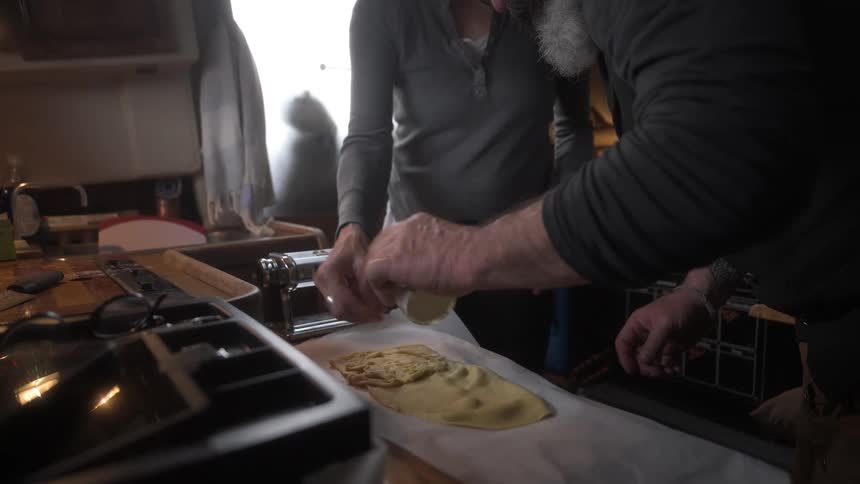 Couple in the kitchen seasoning bread dough