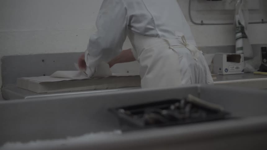 A man wraps meat in paper
