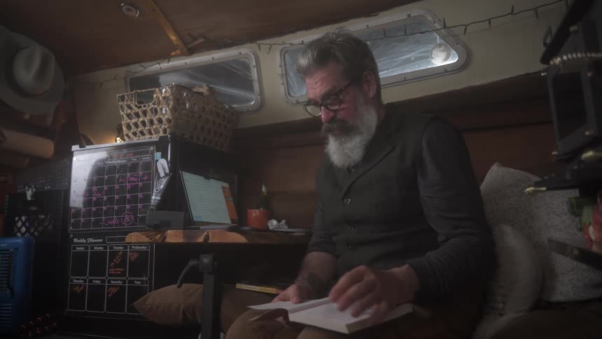 Man with book in hands sitting and talking