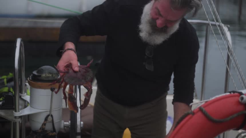 Fisherman inside a boat holding a crab