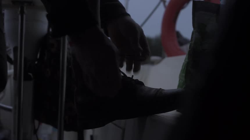 Close up of a pair of hands tying boot laces