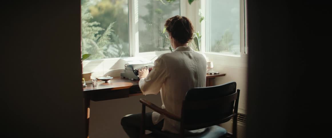 Man sitting typing on a vintage typewriter