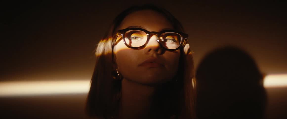 Portrait of a woman with prescription glasses and a beam of light in her eyes