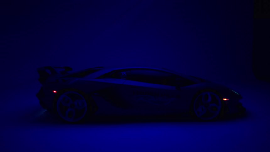 Sports car in profile under intense blue lighting