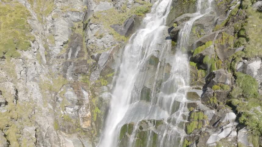 A waterfall runs off the mountain cliff