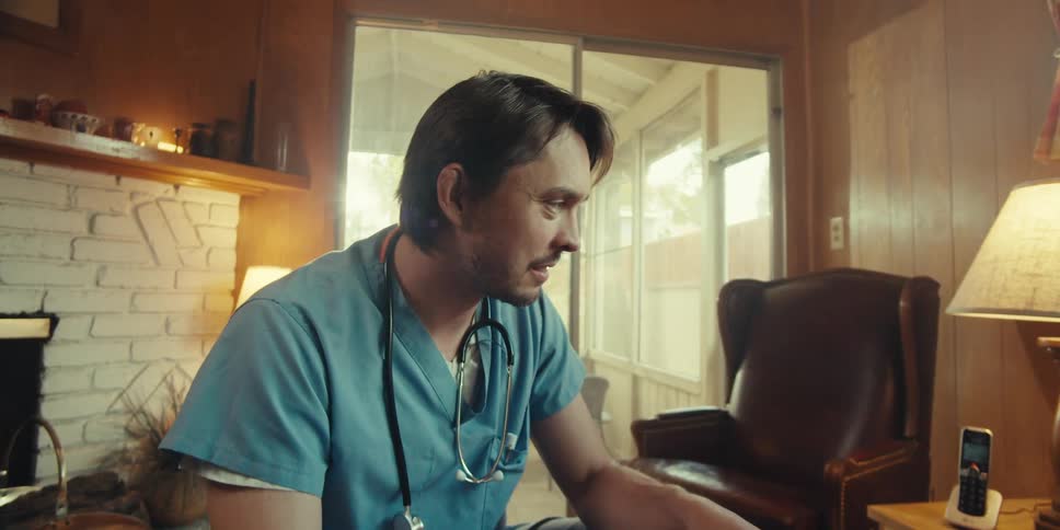 Charismatic nurse talking to elderly man in living room