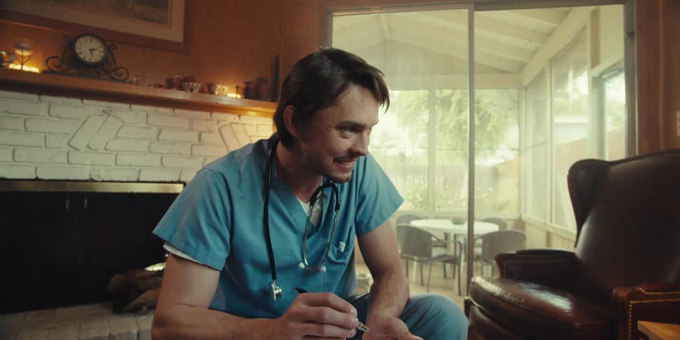 Nurse in a home visit with an elderly gentleman sitting in the living room