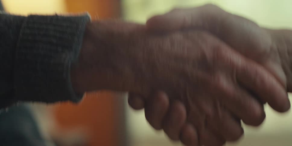 Two people holding hands greeting each other