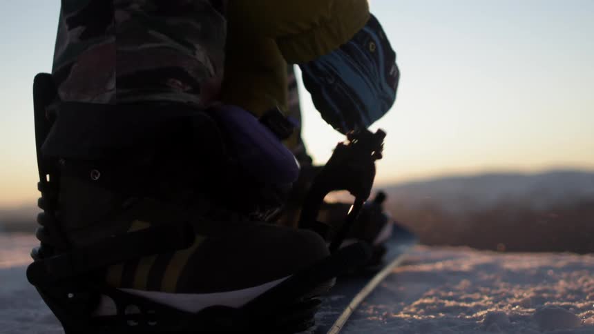 Strapping on a snowboard
