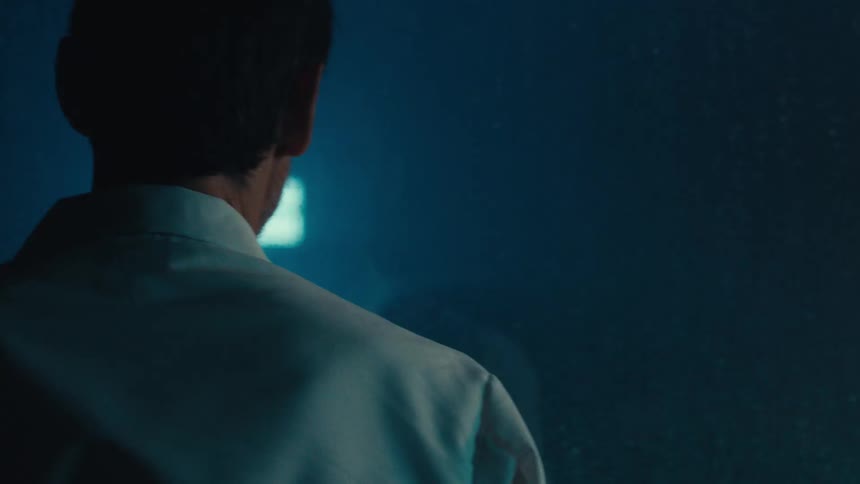 Man in white coat observing an experiment