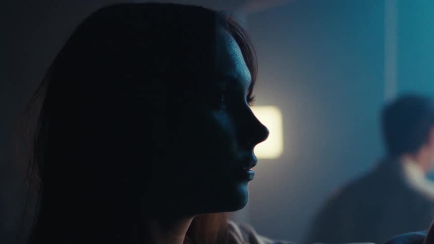 Side portrait of a woman in a laboratory and a man in the background