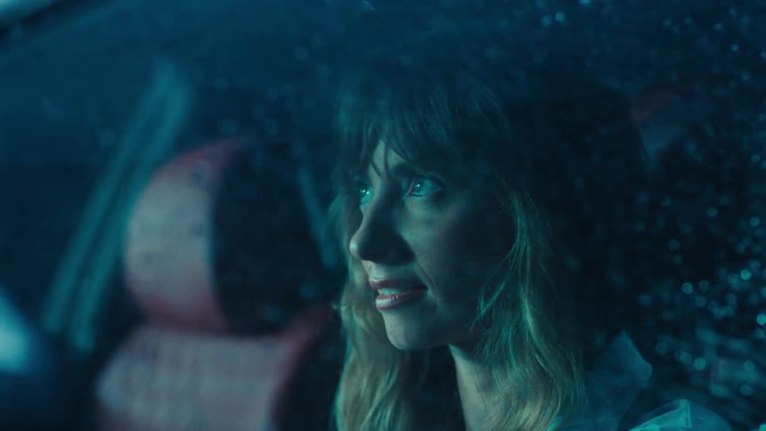 Woman inside a car with rain on the windshield and windows