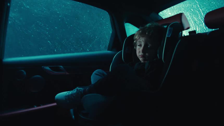 Child sleeping in car while its raining and lighting from thunderstrom