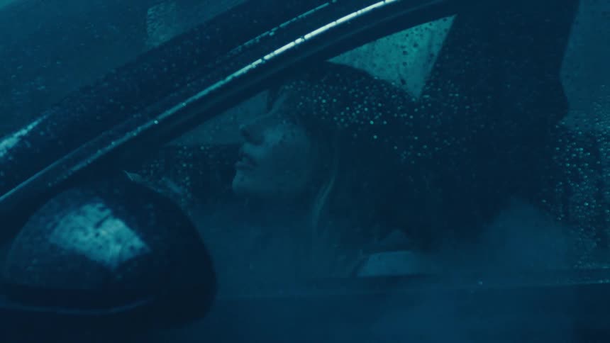 Woman inside a car watching the rain fall