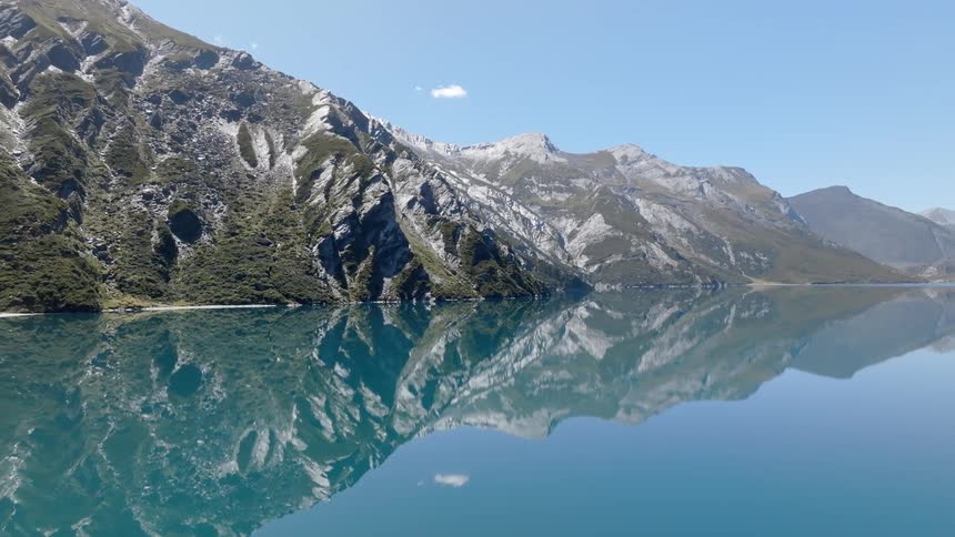 Landscape of a calm lake reflecting the surrounding mountains