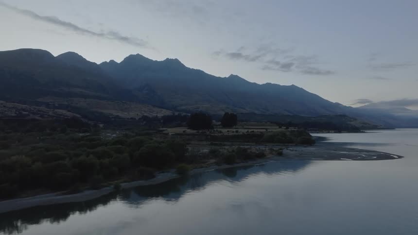 Landscape of a calm lake surrounded by mountains at dawn
