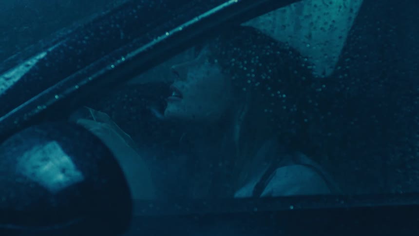 Woman inside a car while it is raining