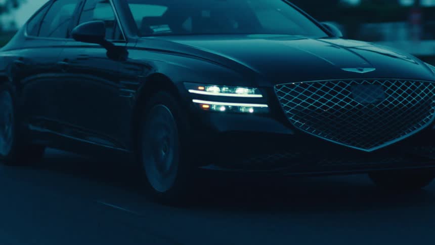 Front of a black sedan vehicle traveling down a highway