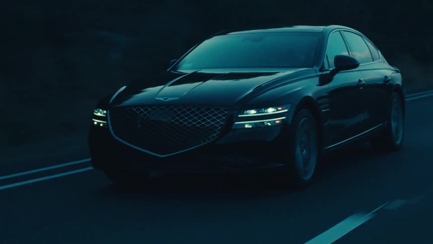 Black sedan car traveling down a road