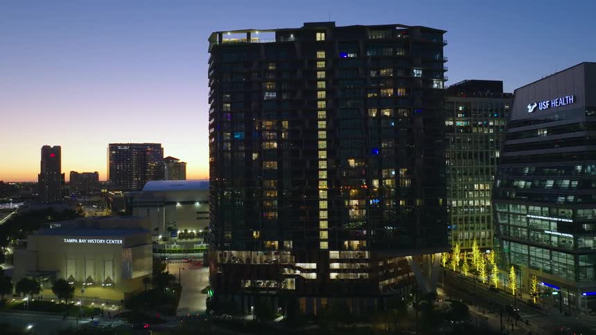 The lights shine in the buildings at dusk