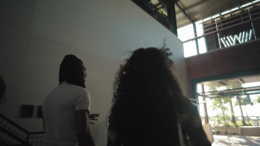Friends talk while walking down the hall