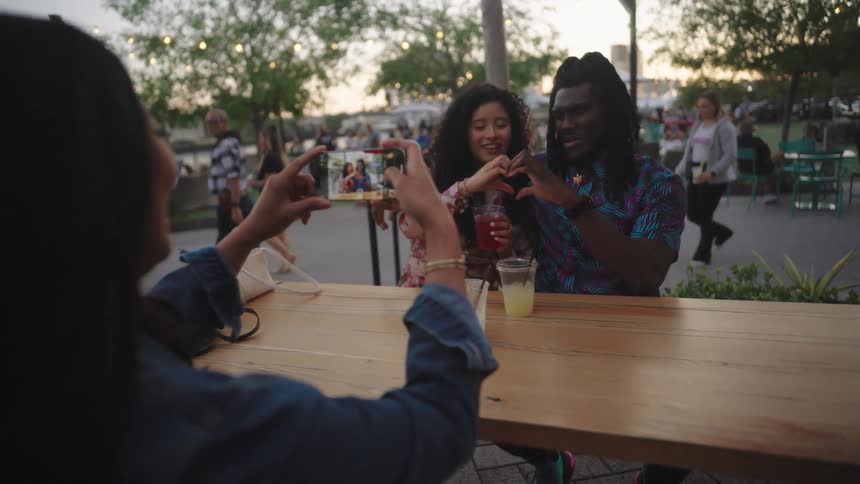 Friends sitting at a table taking extroverted photos
