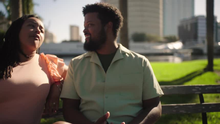Woman and a man sitting on a bench in a square talking