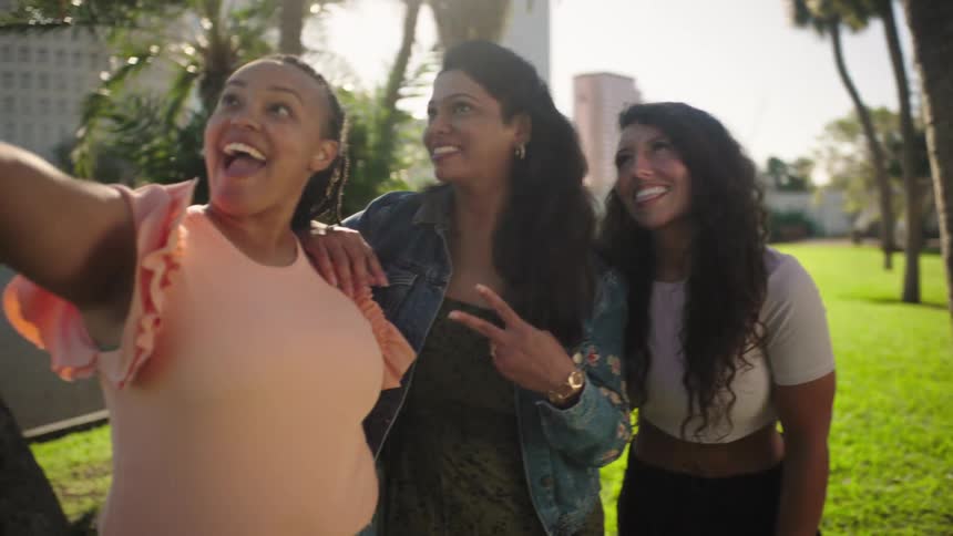Three women take a selfie together by the water