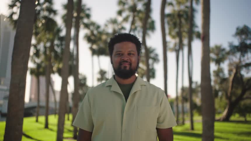 A man is smiling in the park on a path