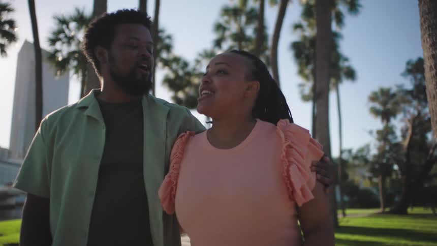 Couple walking together outdoors with palm trees
