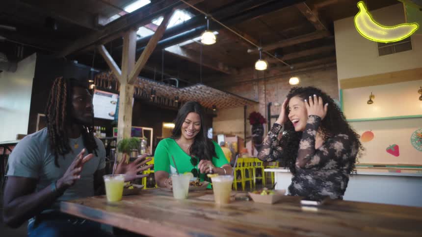 Friends sitting at a bar table talking