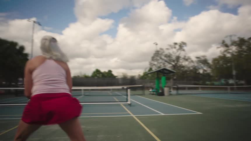A woman is playing a game of pickleball