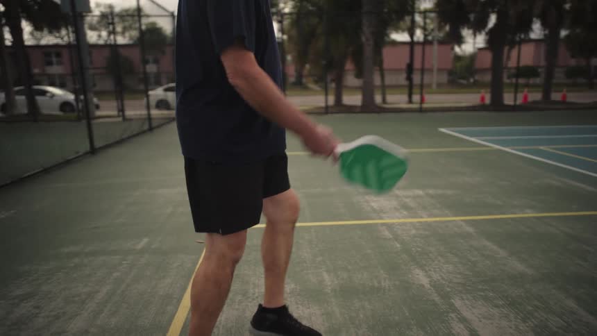 A man runs to hit the ball during a pickleball game