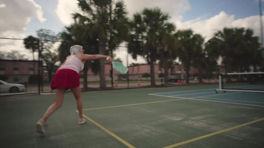 A woman hits the ball in a pickleball match