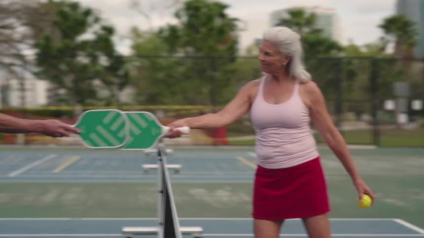 Two players walk to the net and slap their rackets together