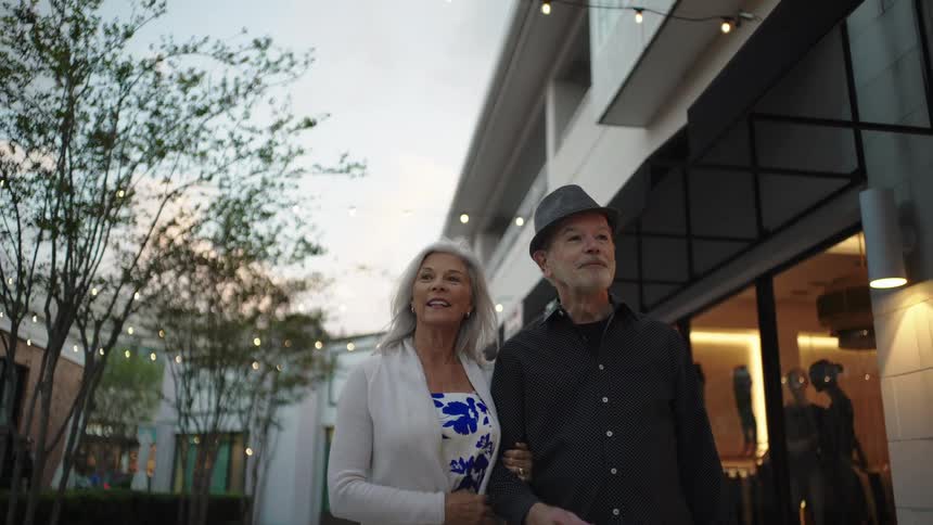 Elderly couple walking through an outdoor gallery