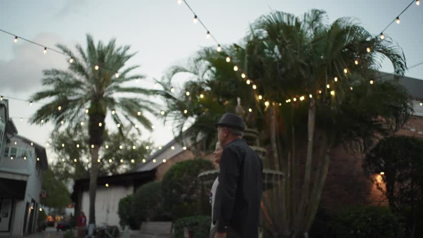 Elderly couple holding hands walking in a restaurant setting