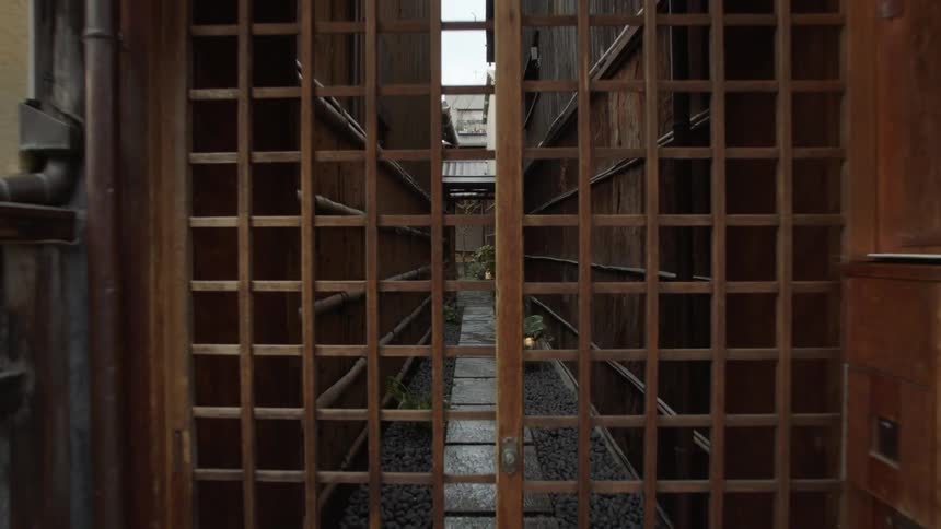 A dark alley is closed by a wooden door